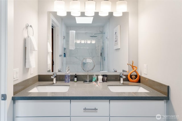 full bathroom with double vanity, a sink, and a shower stall