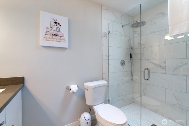 bathroom featuring toilet, a shower stall, and vanity