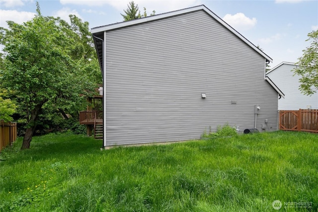 view of side of property featuring fence and a wooden deck