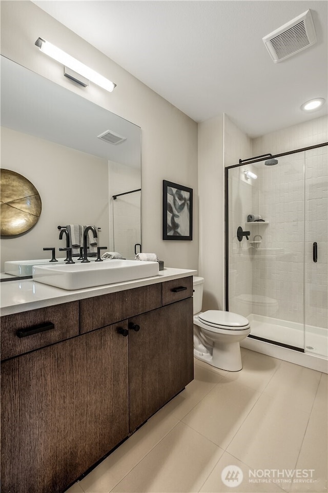 bathroom with visible vents, toilet, a shower stall, vanity, and tile patterned floors