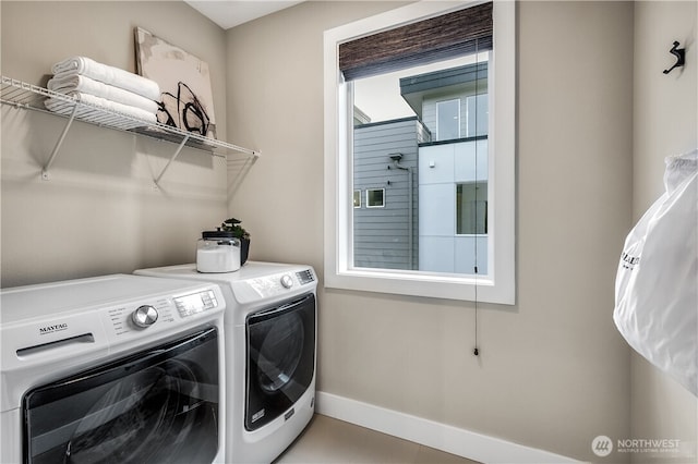 laundry room featuring laundry area, washing machine and dryer, and baseboards