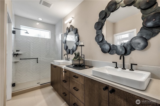 full bathroom with a stall shower, visible vents, a sink, and double vanity