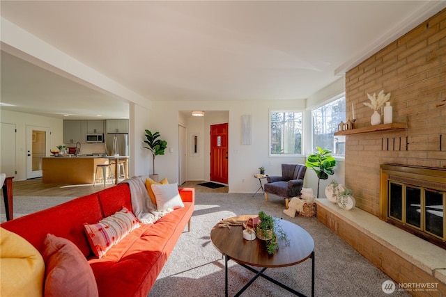 living room with a brick fireplace and light colored carpet