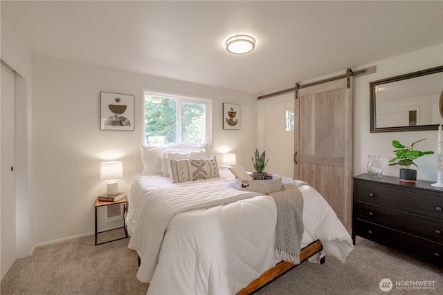 bedroom with light carpet and a barn door