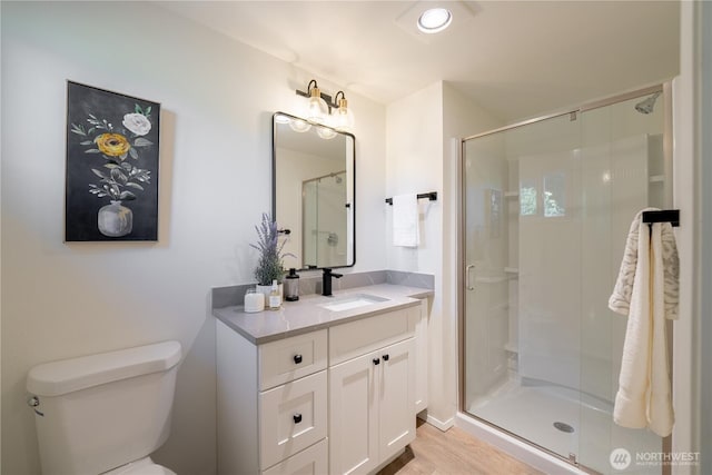 bathroom featuring a stall shower, vanity, and toilet