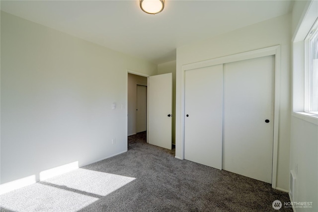 unfurnished bedroom with carpet floors and a closet