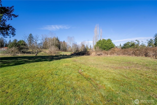 view of yard with a rural view and fence