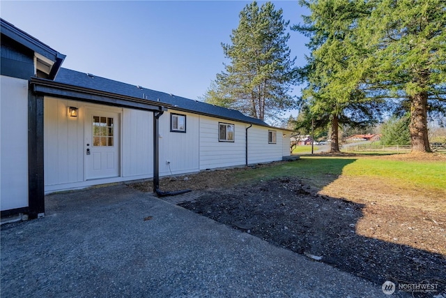 exterior space featuring a shingled roof and fence