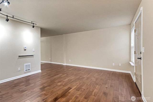 unfurnished living room with baseboards, visible vents, and dark wood-type flooring