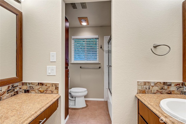 bathroom with tasteful backsplash, baseboards, toilet, combined bath / shower with glass door, and vanity