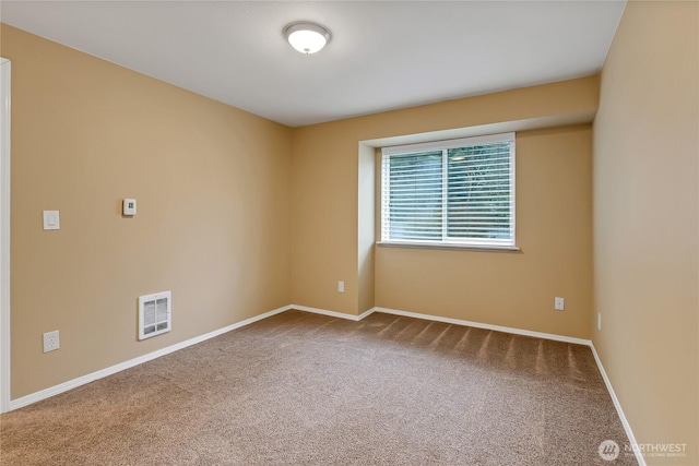 carpeted spare room with visible vents and baseboards