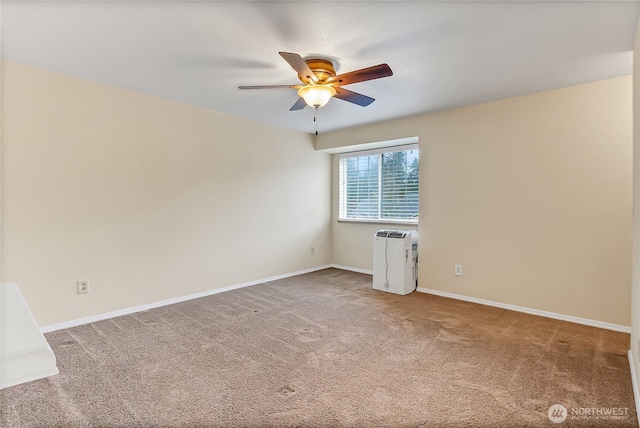 spare room featuring carpet flooring, a ceiling fan, and baseboards