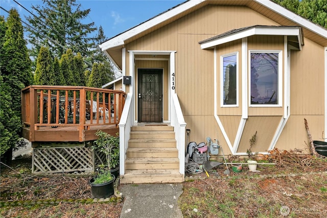 view of exterior entry featuring a wooden deck