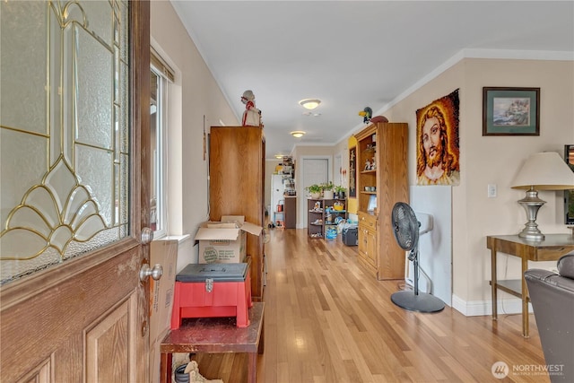 corridor featuring crown molding, baseboards, and wood finished floors