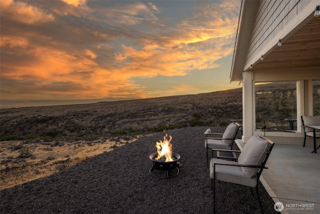 patio terrace at dusk featuring a fire pit