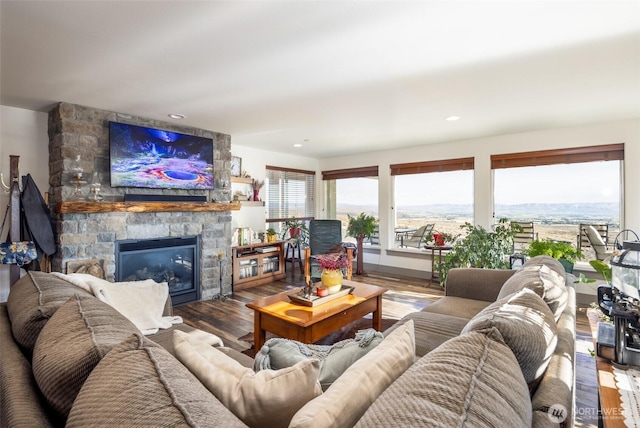 living area featuring recessed lighting, a healthy amount of sunlight, a fireplace, and wood finished floors