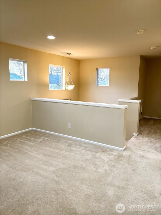 spare room featuring baseboards, a healthy amount of sunlight, recessed lighting, and light colored carpet