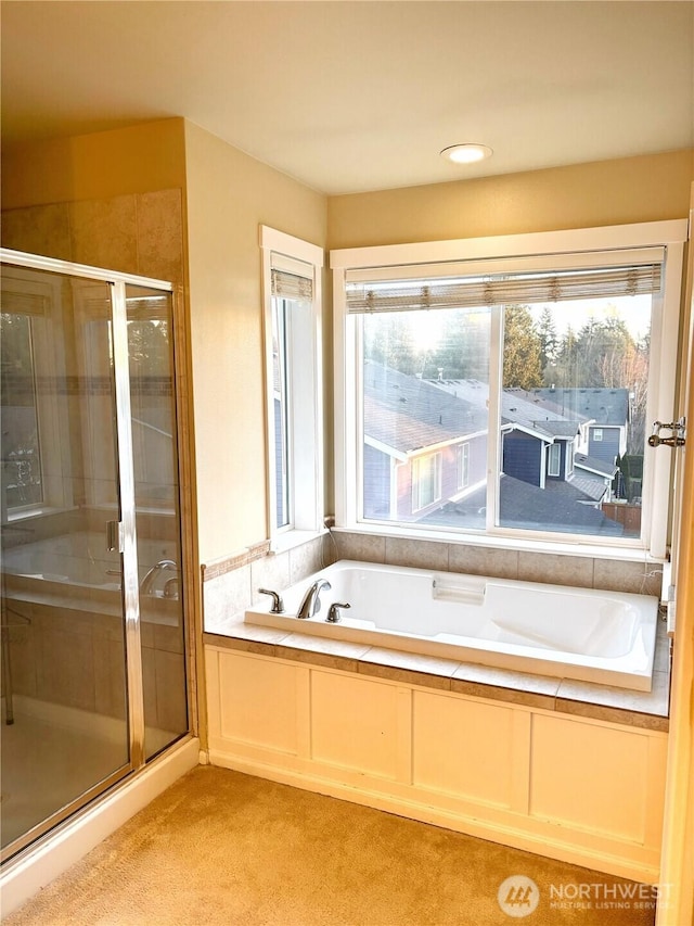 bathroom featuring a stall shower and a bath