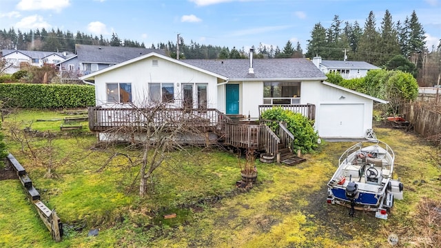 rear view of property featuring a deck, roof with shingles, and a lawn