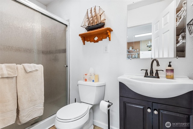 bathroom featuring a stall shower, vanity, and toilet