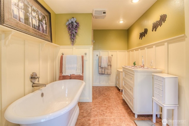 bathroom featuring a wainscoted wall, recessed lighting, a decorative wall, tile patterned flooring, and a freestanding tub