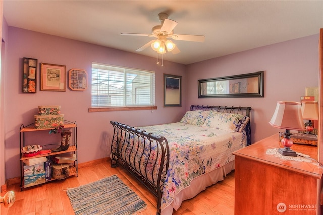 bedroom featuring ceiling fan, light wood-style flooring, and baseboards