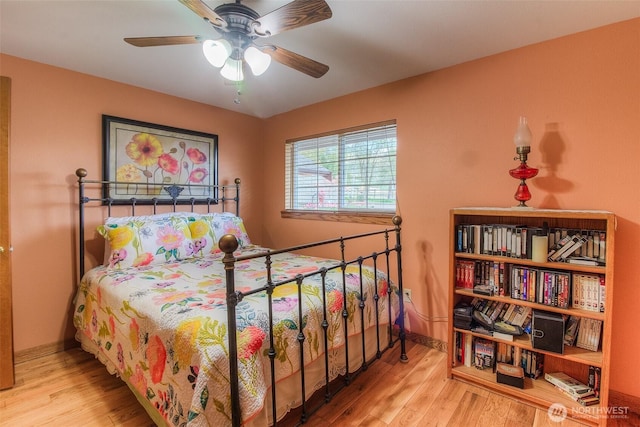 bedroom with ceiling fan, baseboards, and wood finished floors