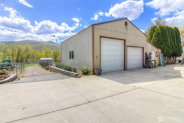 detached garage with a mountain view and fence