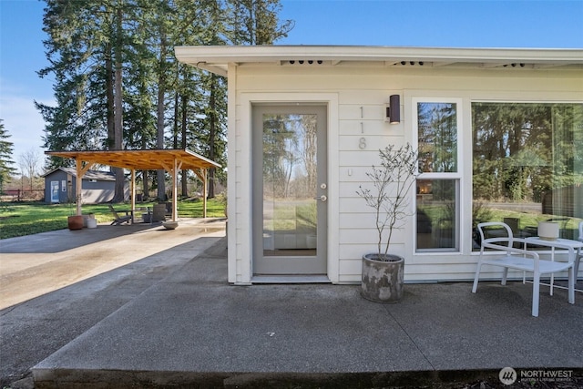 property entrance with a carport, a patio area, and driveway