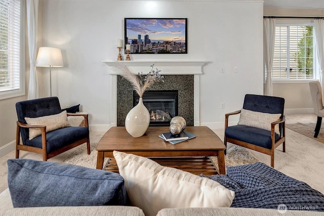 living area with a wealth of natural light, carpet floors, baseboards, and a premium fireplace