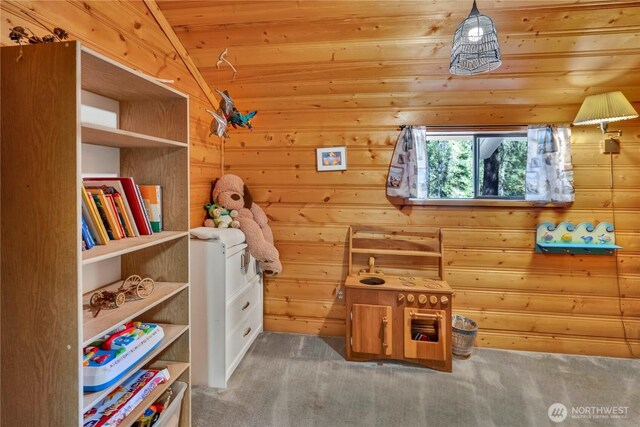 interior space featuring carpet floors, wooden ceiling, wooden walls, and vaulted ceiling