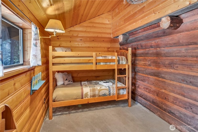 unfurnished bedroom featuring wooden ceiling, wood walls, and concrete flooring