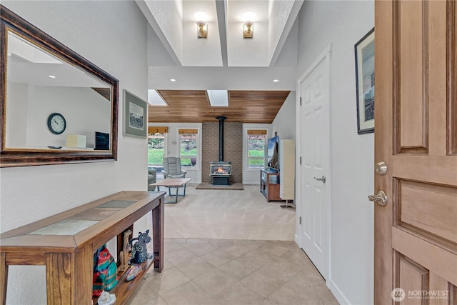 entrance foyer with light carpet, light tile patterned floors, wood ceiling, a wood stove, and recessed lighting