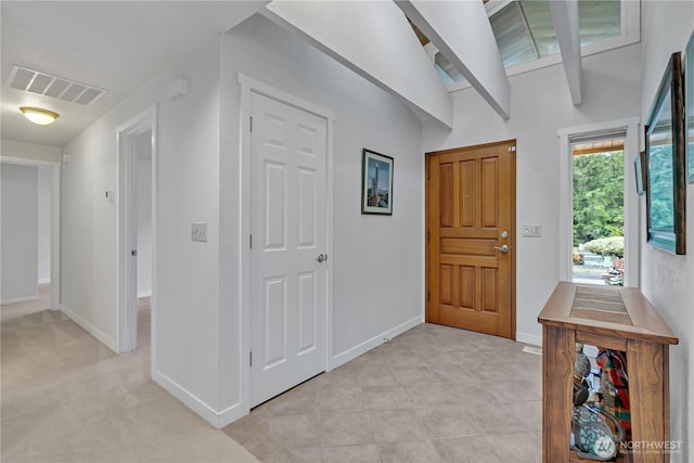 foyer featuring baseboards and visible vents