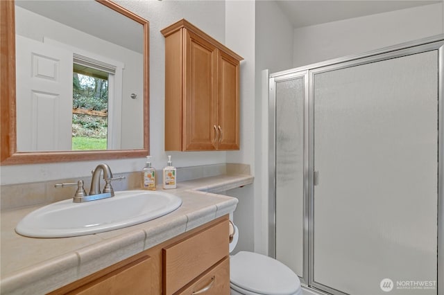 full bath with toilet, a stall shower, and vanity