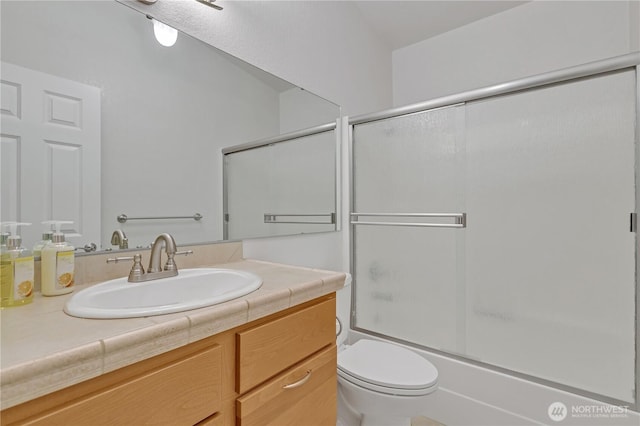 bathroom featuring shower / bath combination with glass door, vanity, and toilet