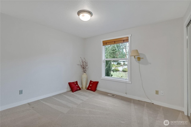 carpeted spare room featuring visible vents and baseboards