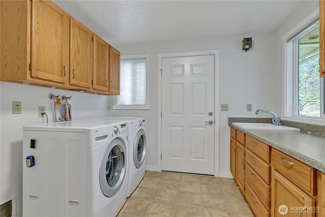 laundry room featuring washer and clothes dryer, a sink, cabinet space, and baseboards