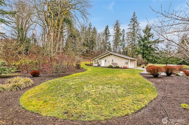 view of yard with a garage and driveway