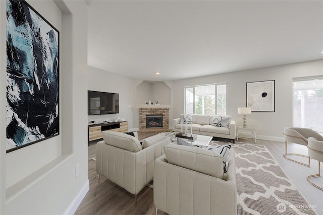 living room featuring recessed lighting, baseboards, a brick fireplace, and wood finished floors