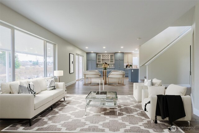 living room with light wood finished floors, recessed lighting, and baseboards