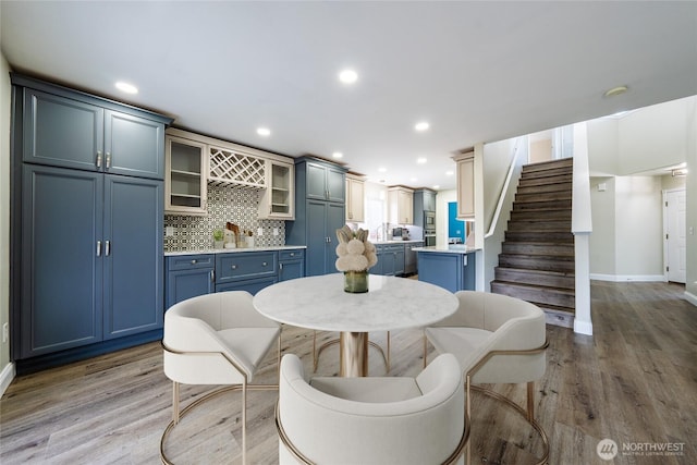 dining area featuring light wood finished floors, recessed lighting, and stairs