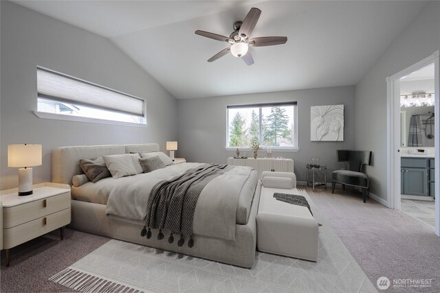 bedroom with baseboards, ceiling fan, carpet, vaulted ceiling, and ensuite bath