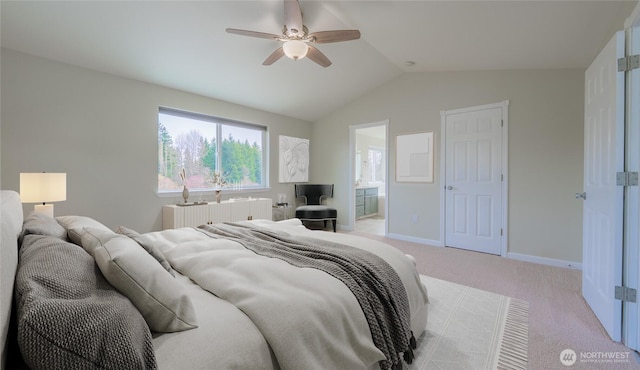 bedroom with baseboards, lofted ceiling, ceiling fan, ensuite bathroom, and light carpet