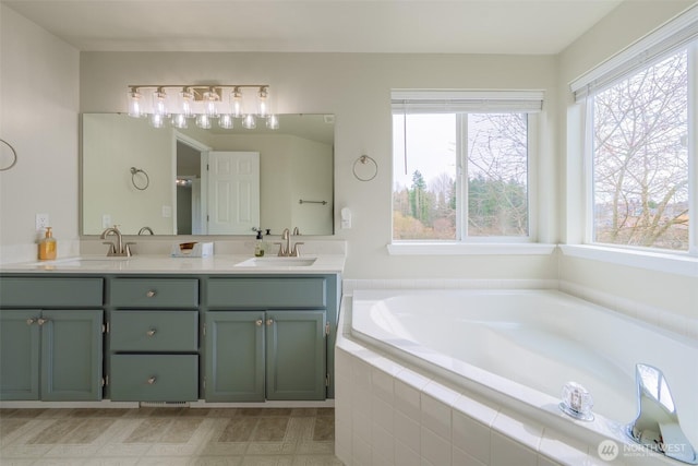 full bath with a sink, plenty of natural light, a bath, and double vanity