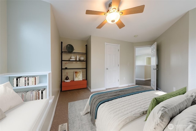 carpeted bedroom with visible vents, baseboards, and a ceiling fan