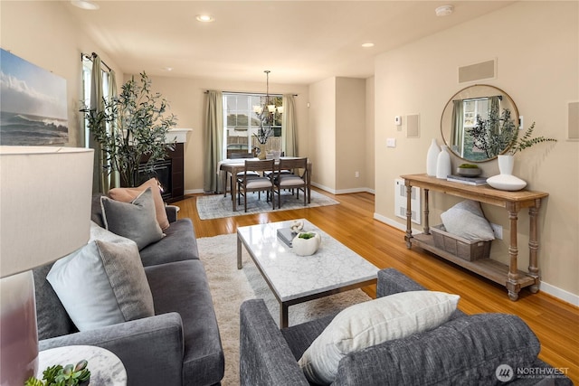 living area with light wood-type flooring, visible vents, baseboards, and recessed lighting