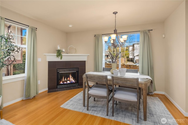 dining area featuring light wood finished floors, a fireplace, and a wealth of natural light