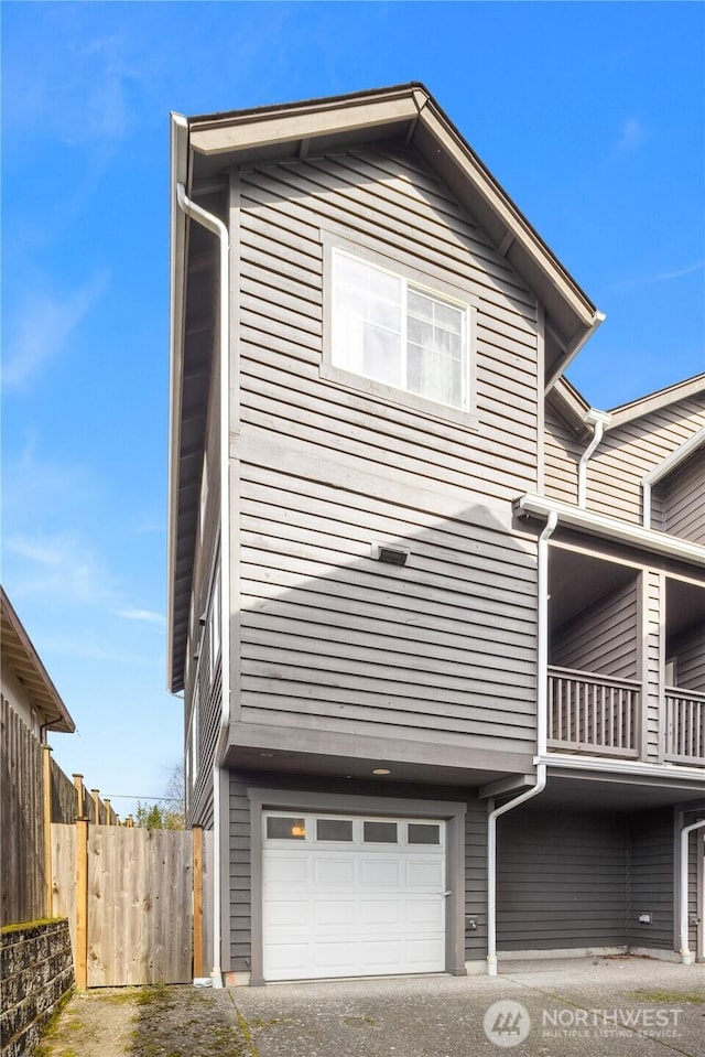 view of front of house with an attached garage and fence