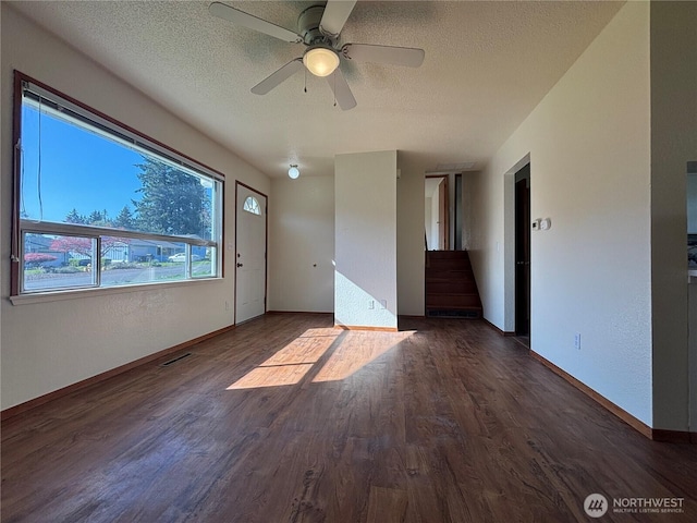 empty room with a ceiling fan, baseboards, wood finished floors, and a textured ceiling